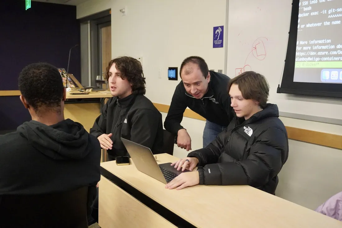 SWECC members gathered around a laptop at a workshop